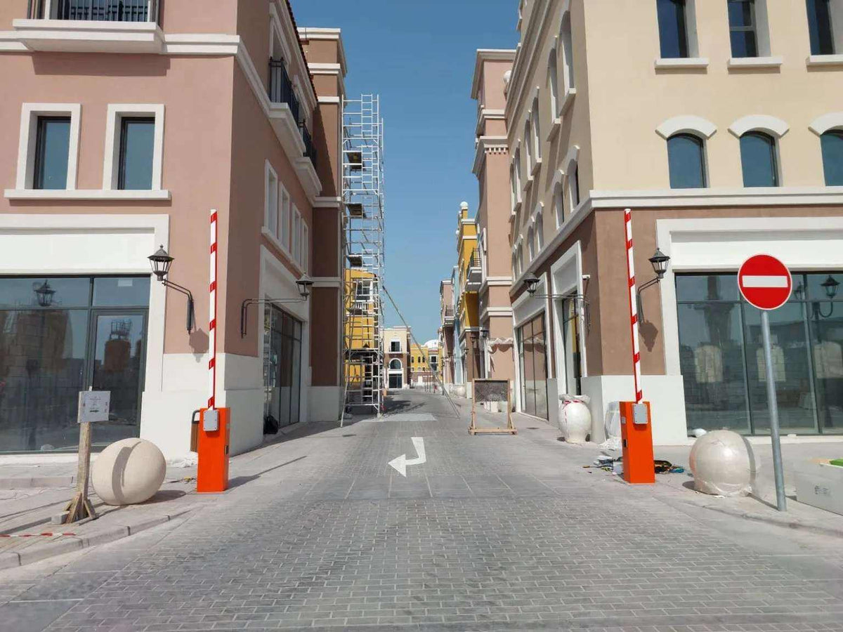 Comunello BORDER 400 Automatic Parking Barrier with orange metal cabinets and raised white booms with red stripes
