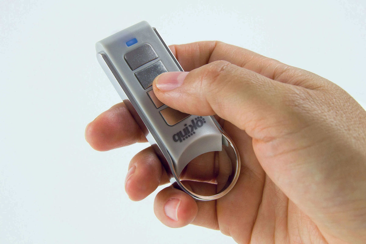 Quiko 4-Channel Gate Remote in silver and grey plastic with four dark buttons, a blue indicator and metal key ring