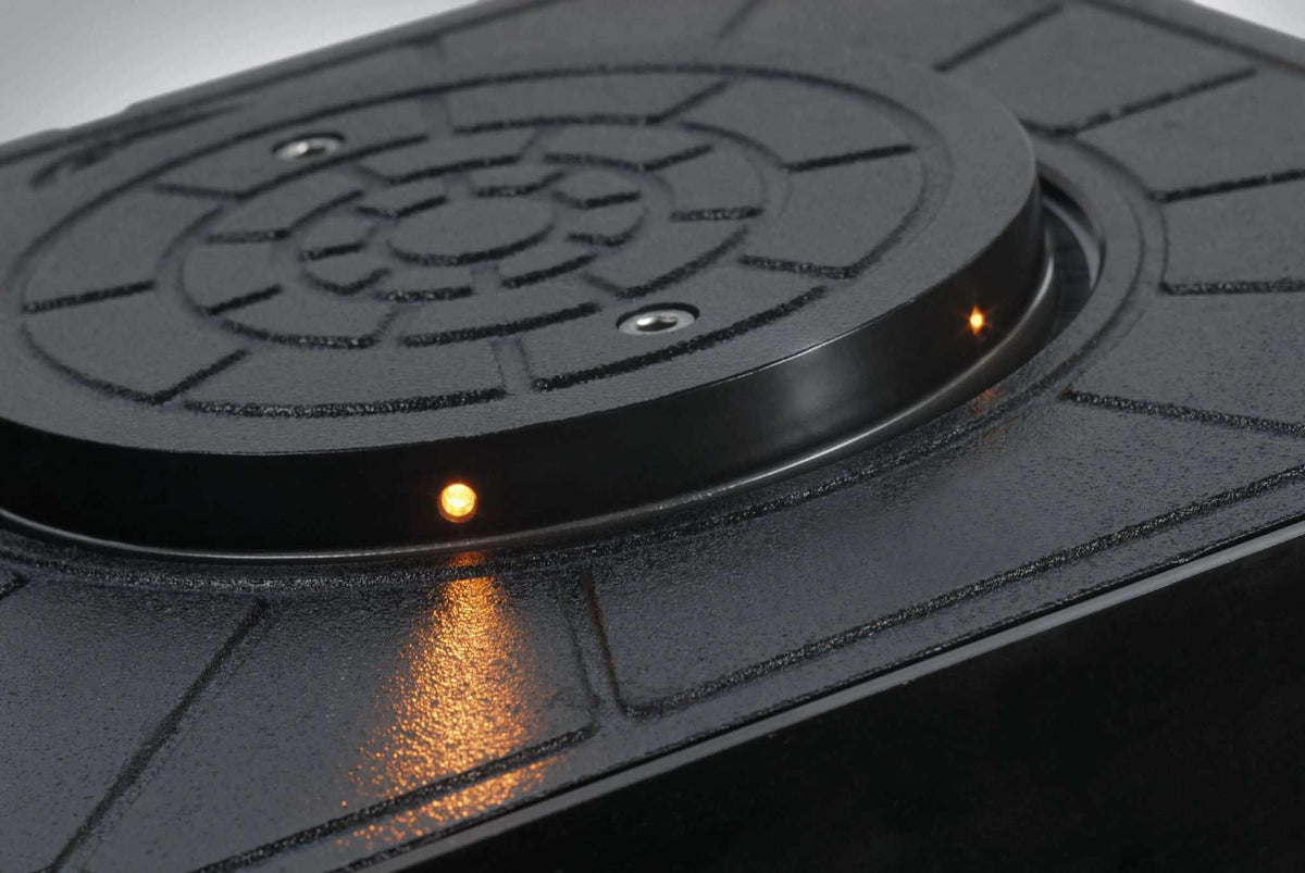 Quiko Automatic Rising Bollards, a black textured metal bollard top with small amber indicator lights and a circular patterned cover.