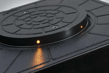 Quiko Automatic Rising Bollards, a black textured metal bollard top with small amber indicator lights and a circular patterned cover.