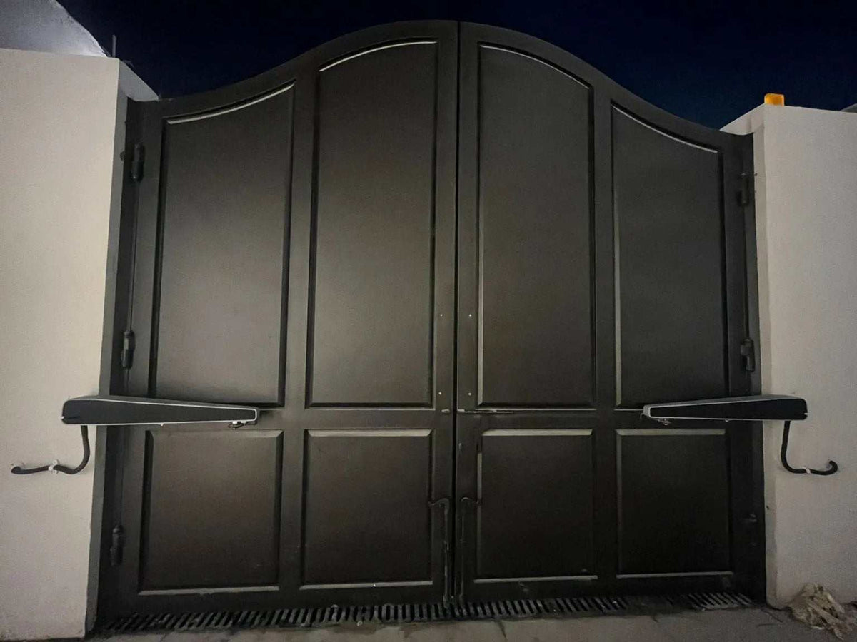 Comunello ABACUS 300 Swing Gate Motor, a dark metal double-leaf swing gate with raised rectangular panels