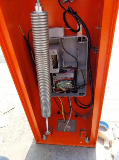 Comunello BORDER 400 Automatic Parking Barrier with an open orange metal cabinet, steel spring and exposed control wiring