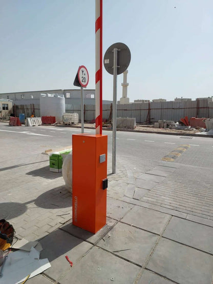 Comunello BORDER 400 Automatic Parking Barrier with an orange metal cabinet and raised red-and-white striped boom
