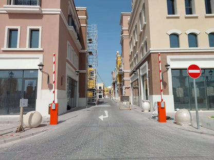 Comunello BORDER 400 Automatic Parking Barrier with orange metal cabinets and raised white booms with red stripes