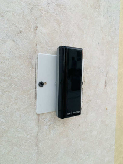 Comunello DART SLIM Gate Safety Photocells with a slim black rectangular sensor housing mounted on a white plate.