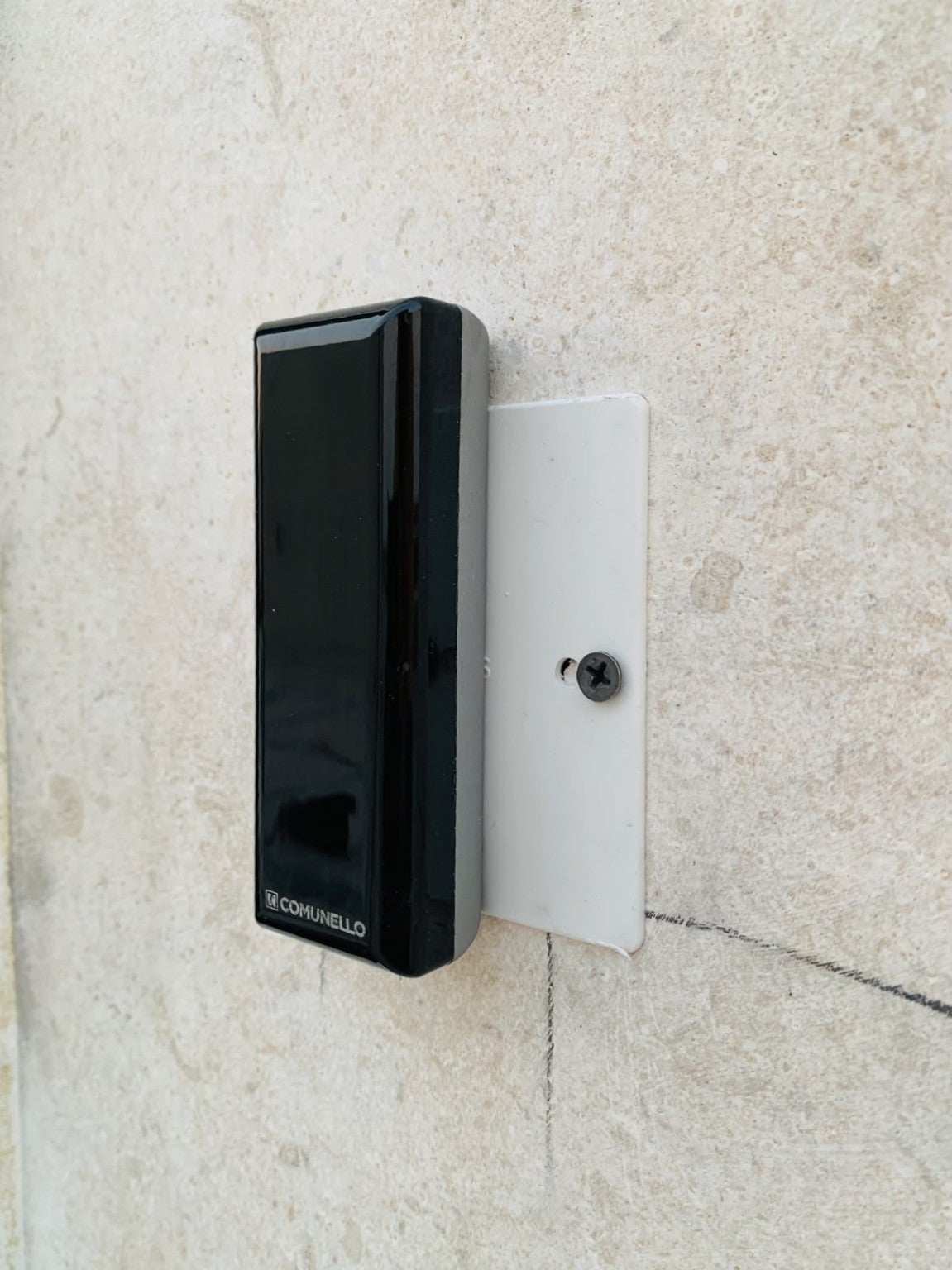 Comunello DART SLIM Gate Safety Photocells, slim black plastic sensor with a glossy front and Comunello logo, mounted on a white bracket.