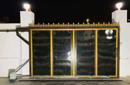 Quiko MOOVY sliding gate operator in Qatar with an ornate black metal sliding gate, gold trim, and glass panels