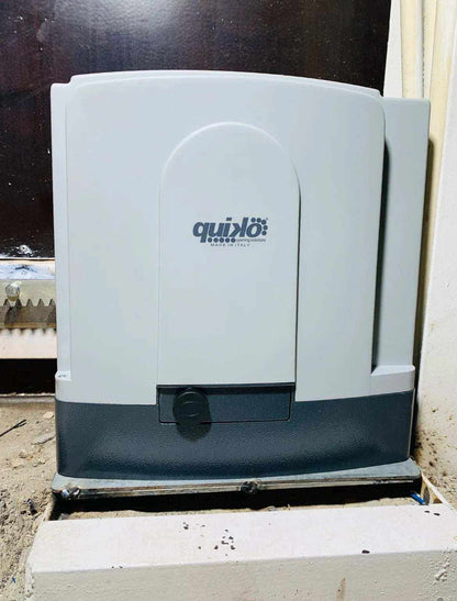 Quiko MOOVY sliding gate operator in Qatar with a white and dark gray housing, branded cover and release knob