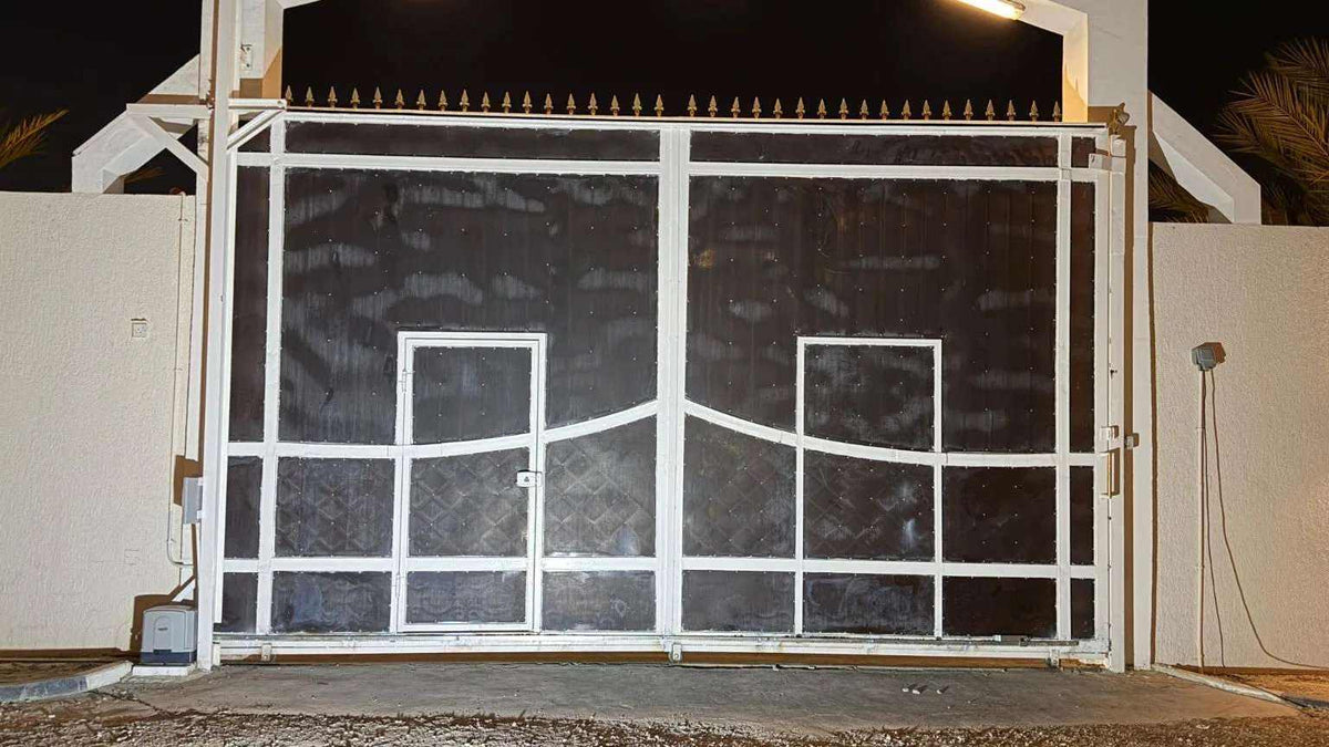Quiko MOOVY sliding gate operator in Qatar, white metal sliding gate with dark panels and pedestrian doors