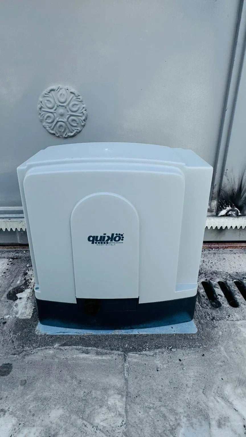 Quiko MOOVY Sliding Gate Operator with a light gray plastic housing, rounded rectangular shape and Quiko logo.