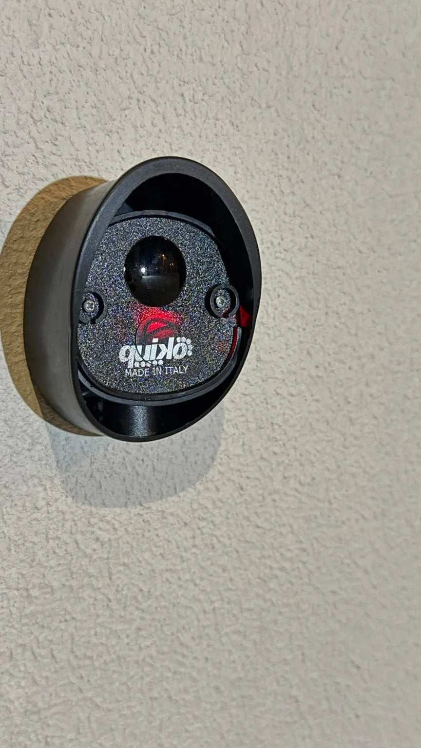 Quiko MOOVY Sliding Gate Operator, black oval control unit with a glossy lens, textured faceplate and red indicator lights.