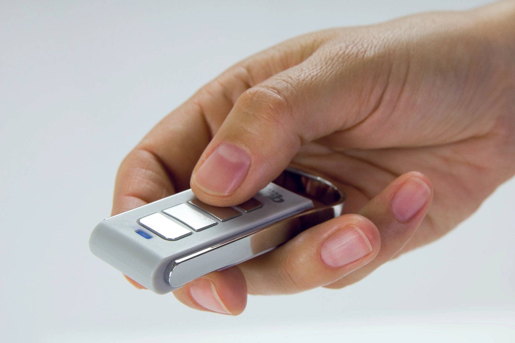 Remotes- Quiko Automation held in a hand, featuring a sleek design and multiple buttons.